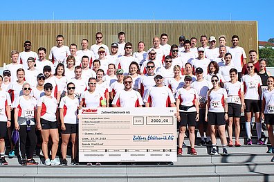 Aufstellung der Mitarbeiter der Zollner Elektronik AG, die am Chamer Stadtlauf teilnahmen, mit dem Spendenscheck in Höhe von 2.000€ für die Chamer Tafel